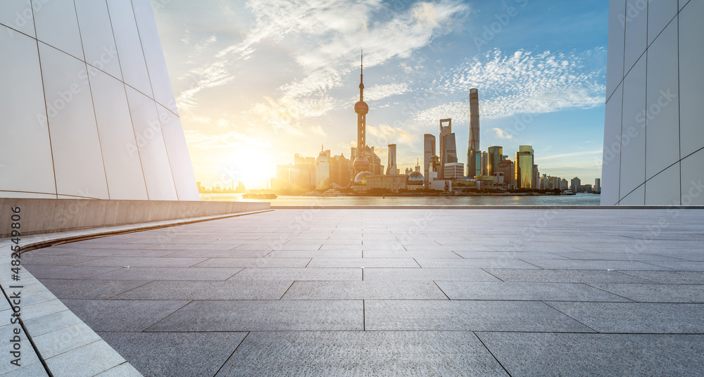 Panoramic skyline and modern commercial buildings with empty square floor in Shanghai at sunrise, Ch