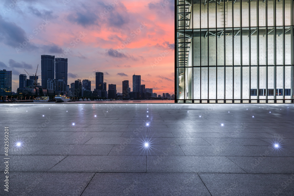 Empty square floor and city skyline with modern commercial office buildings at sunrise in Shanghai, 