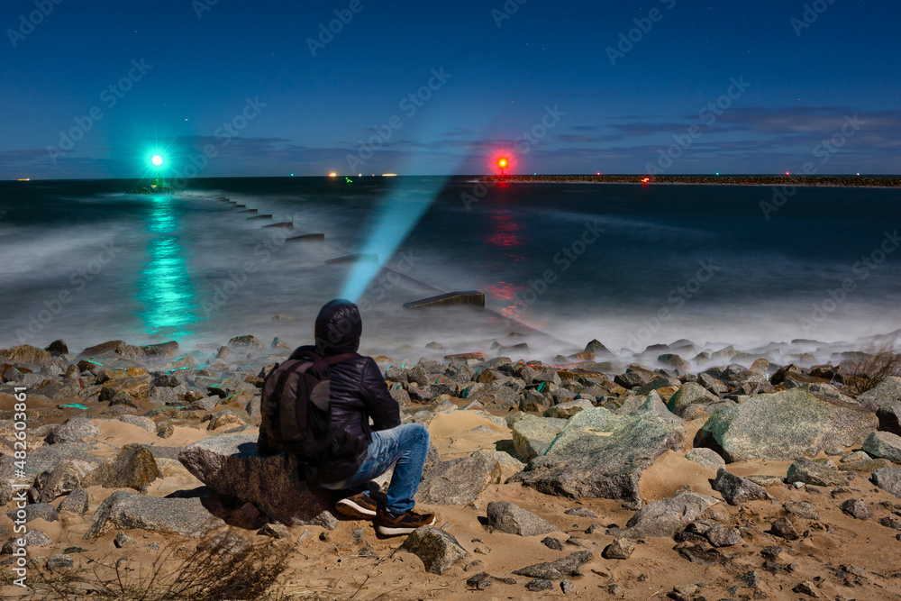 Man on the stormy Baltic Sea beach at night. Gdansk, Poland