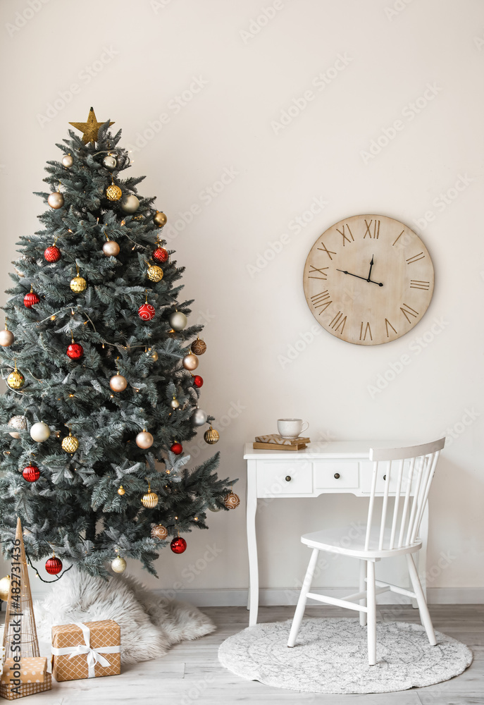 Stylish interior with Christmas tree and clock on light wall