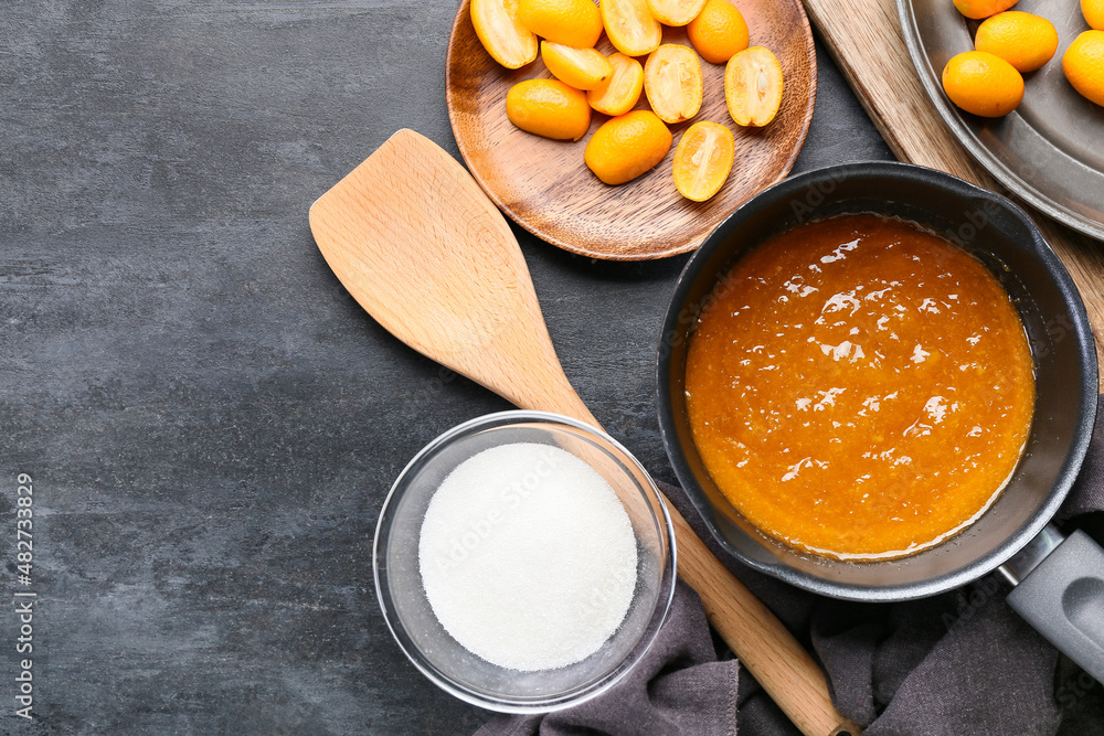 Preparing of tasty kumquat jam on table