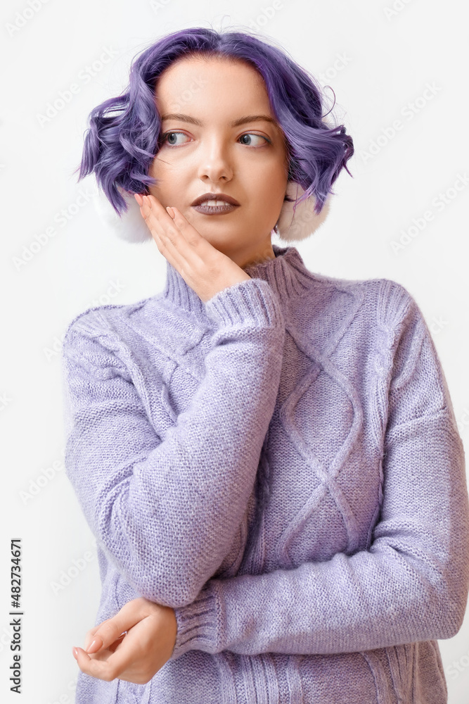 Beautiful young woman with violet hair and fluffy headphones on white background. Very Peri - color 