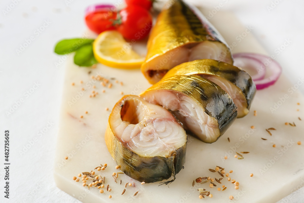 Board with cut smoked mackerel fish on light background, closeup