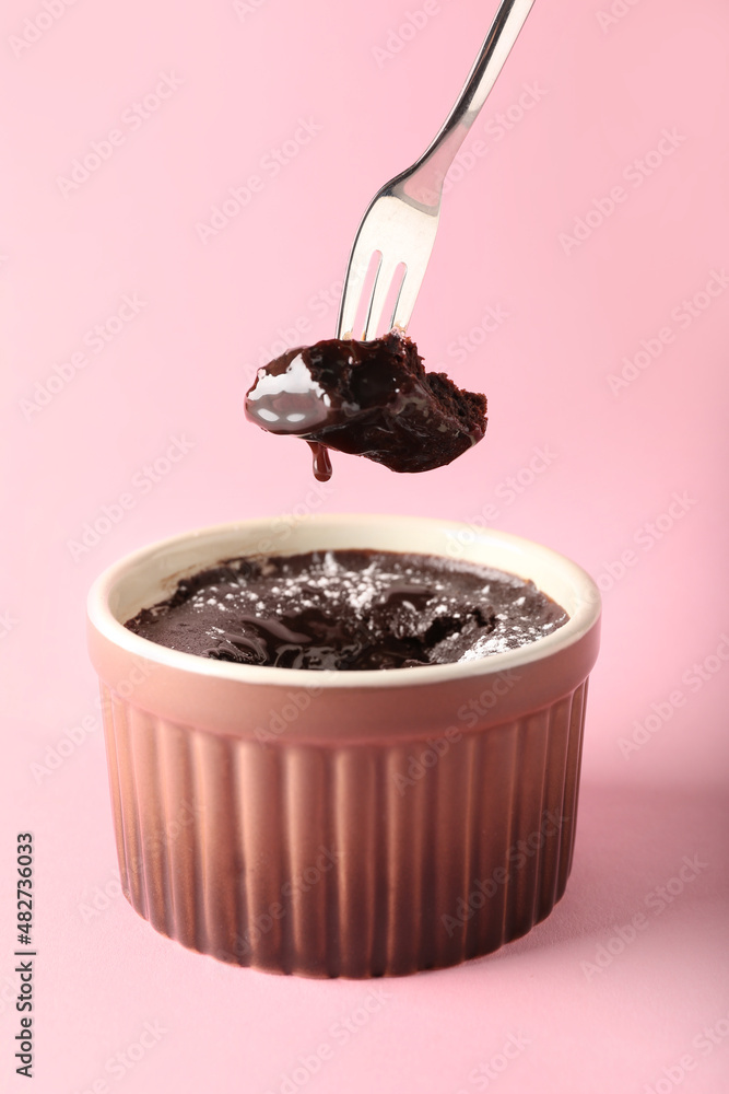 Ramekin with tasty lava cake fondant on pink background