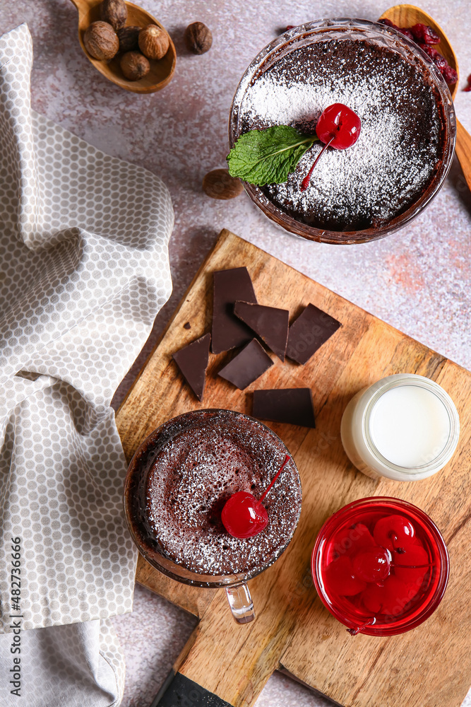 Glass bowl and cup with tasty chocolate brownie on light background