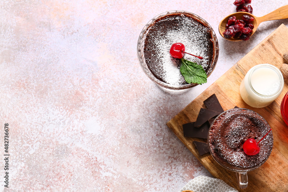 Glass bowl and cup with tasty chocolate brownie on light background