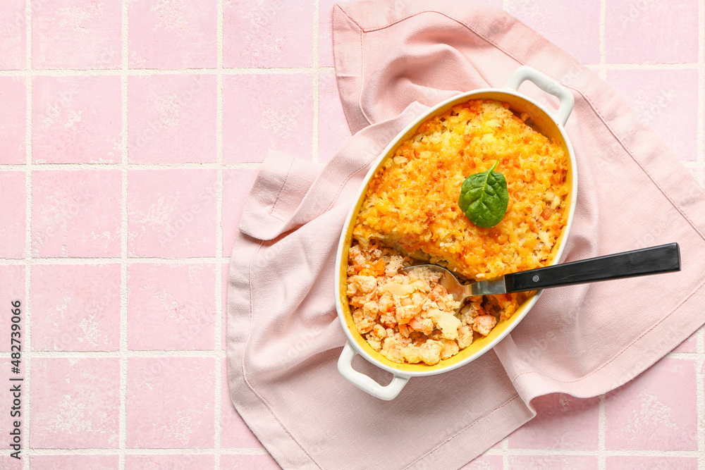 Baking dish with tasty English fish pie on tile background