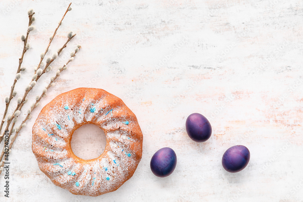 Tasty Easter cake, eggs and willow branches on light background