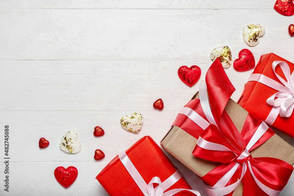 Valentines Day gifts and hearts on white wooden background