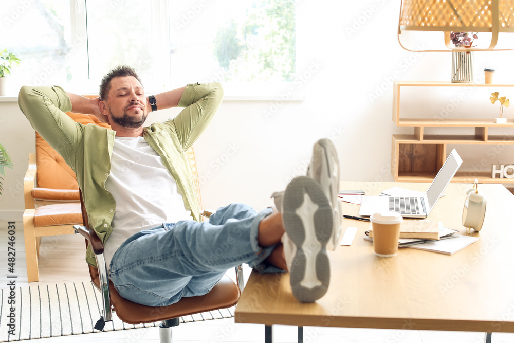 Handsome man relaxing at table in office