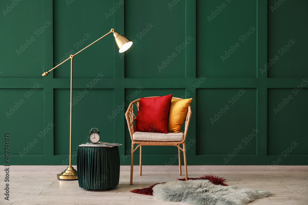 Interior of room with wicker chair and floor lamp near color wall