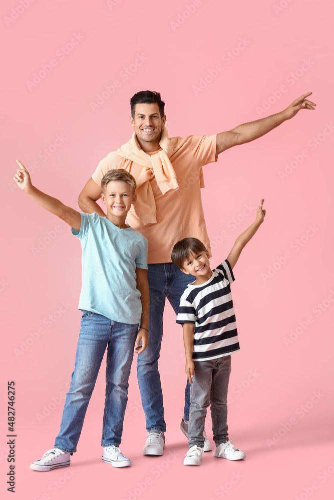 Happy man and his sons on color background