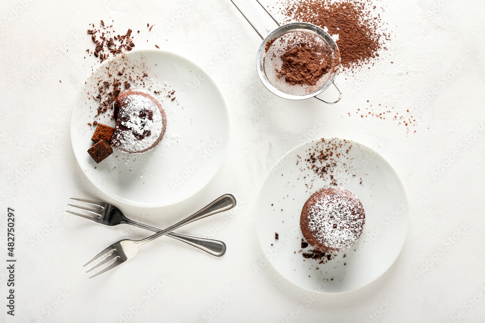 Plates with tasty lava cake fondant on light background