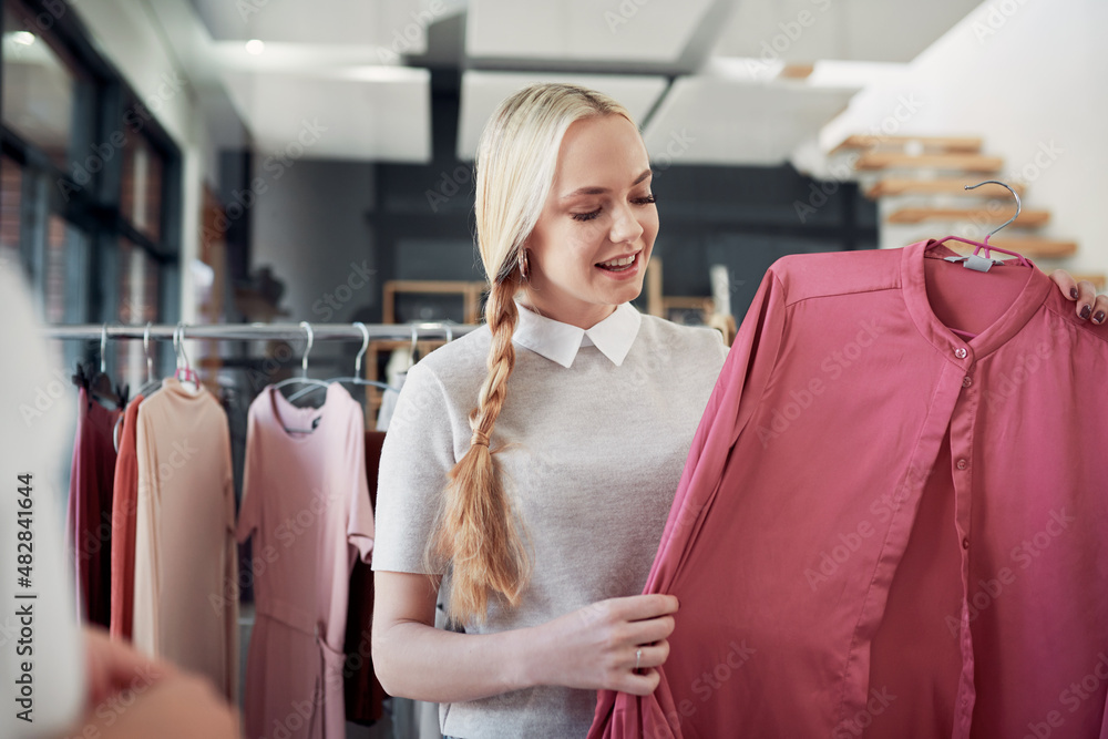 I love this fabric. Shot of a young woman shopping for clothes in a store.