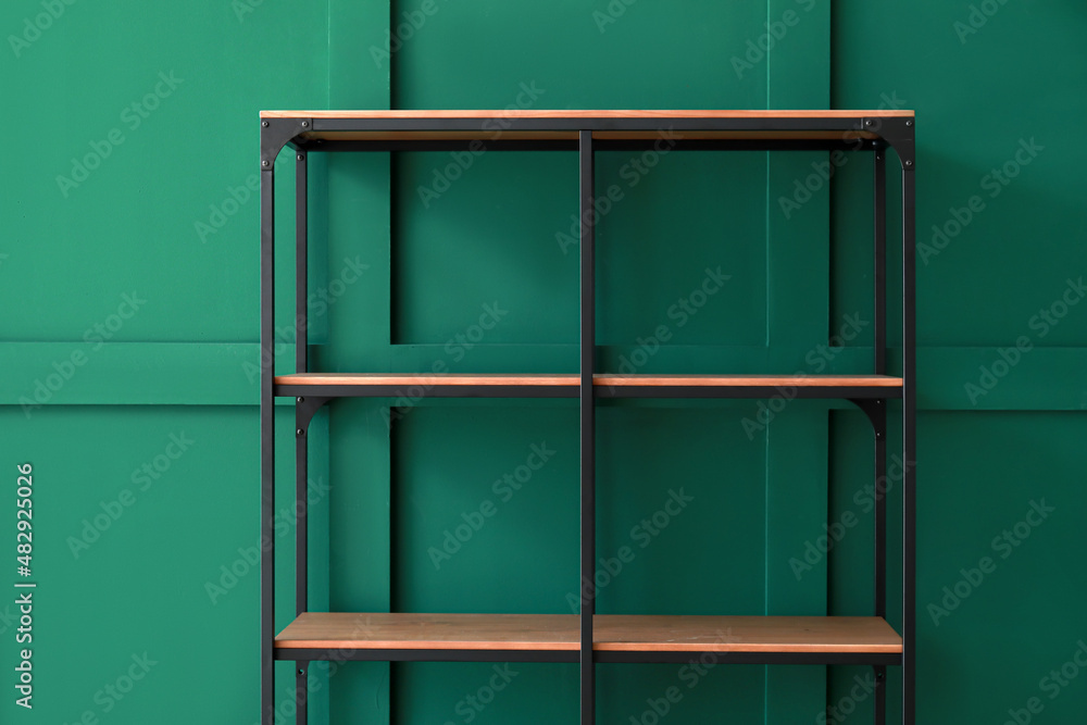 Empty shelf unit near green wall