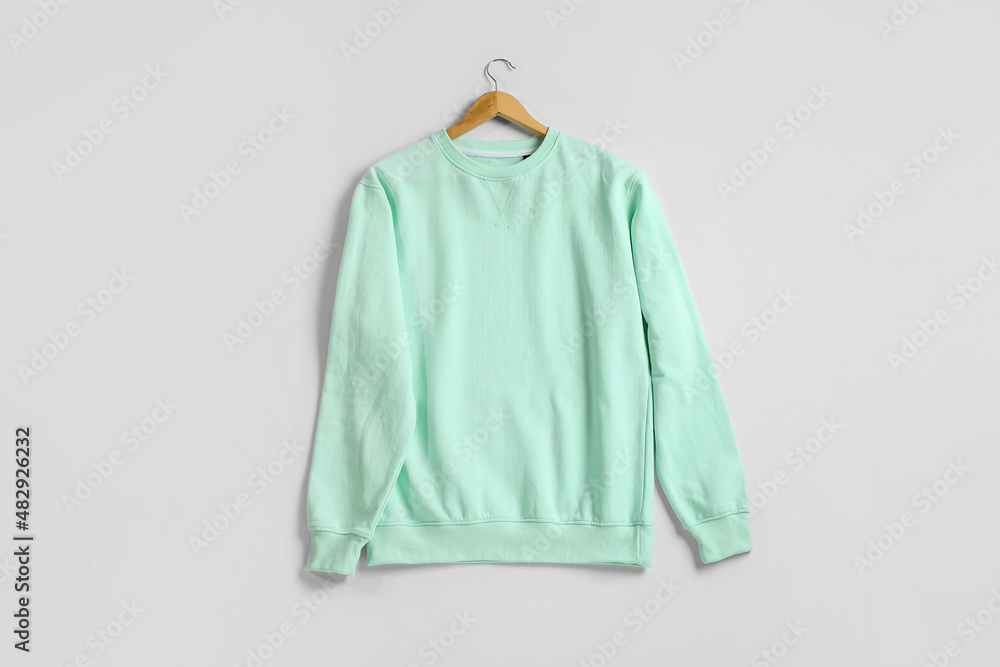 Stylish mint sweatshirt on white background