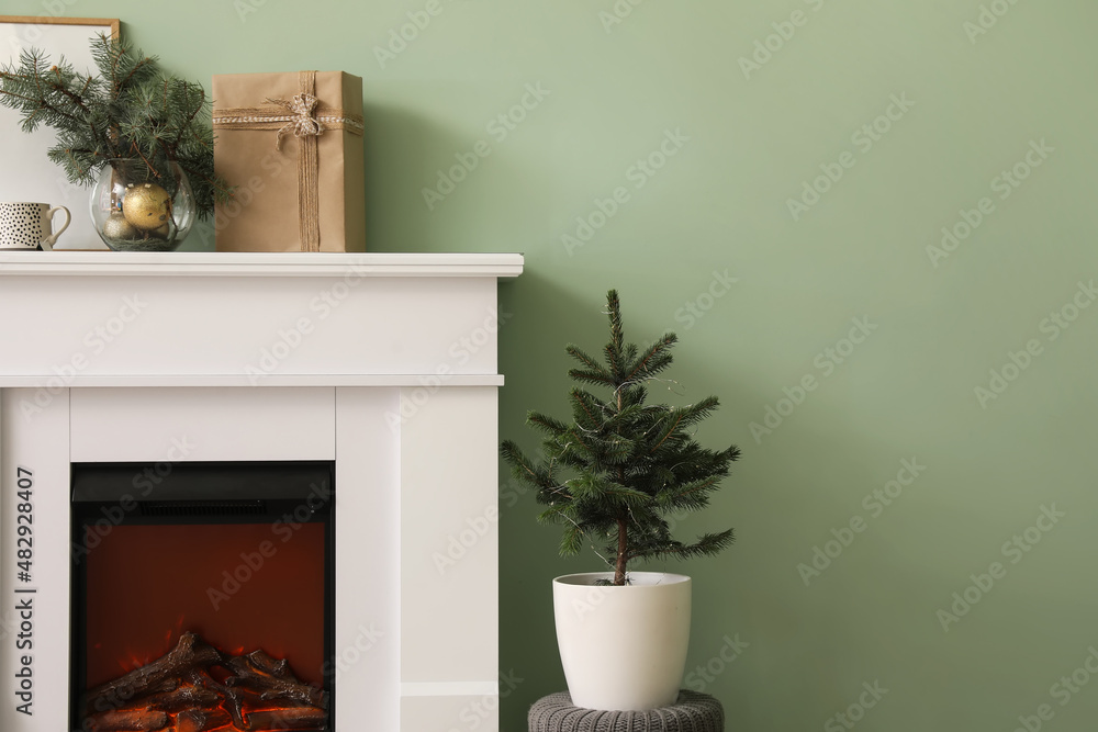 Fireplace and Christmas trees near color wall in room