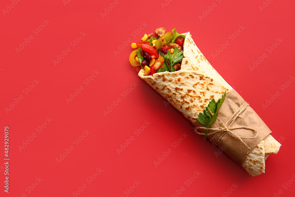 Delicious burrito on red background