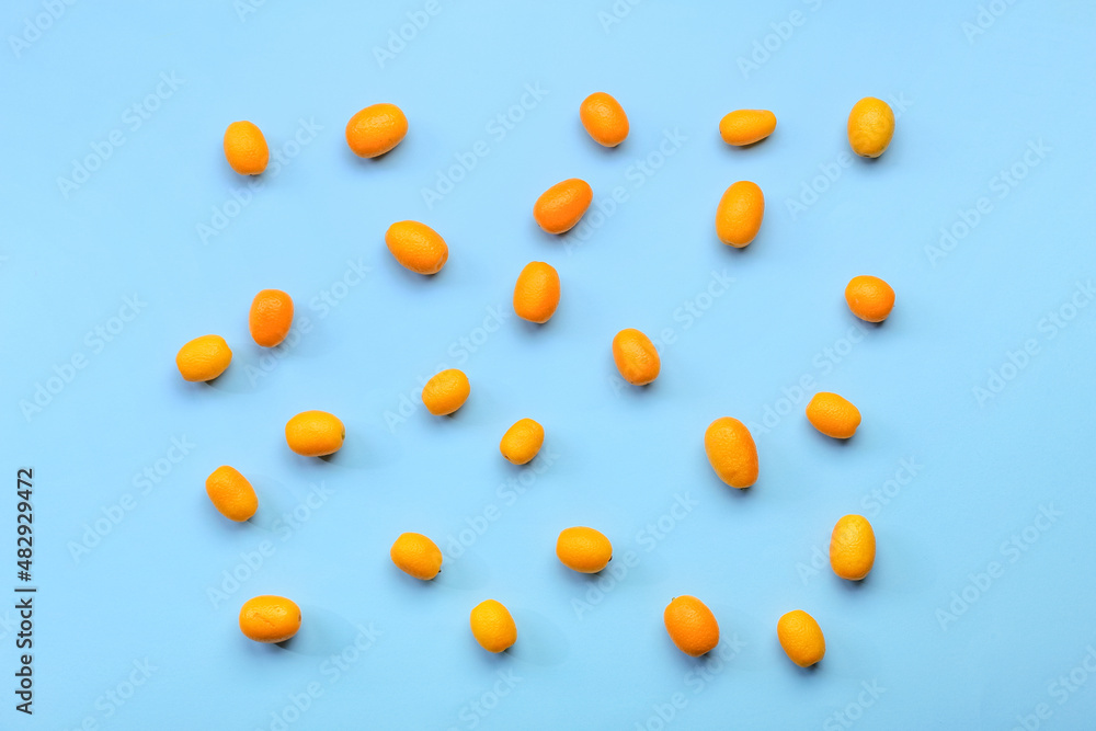 Tasty kumquat fruits on blue background