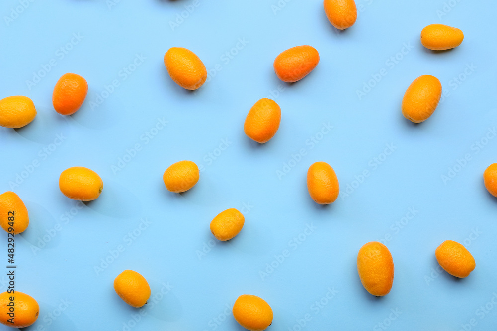 Tasty kumquat fruits on blue background