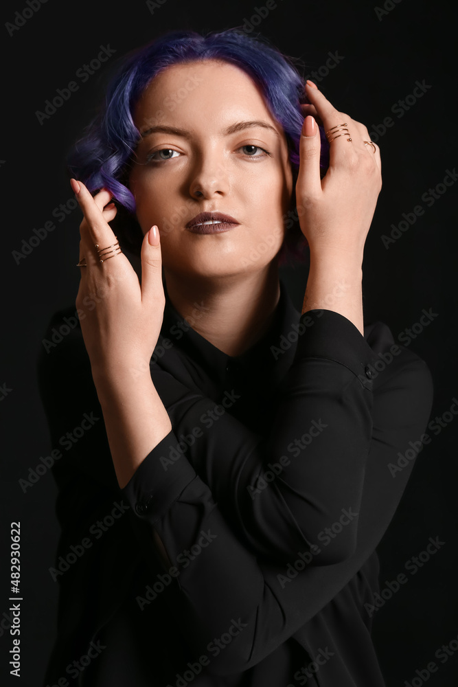 Beautiful young woman with violet hair on black background. Very Peri - color of year 2022