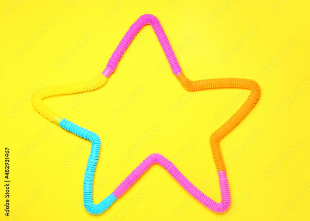 Star made of Pop Tubes on yellow background