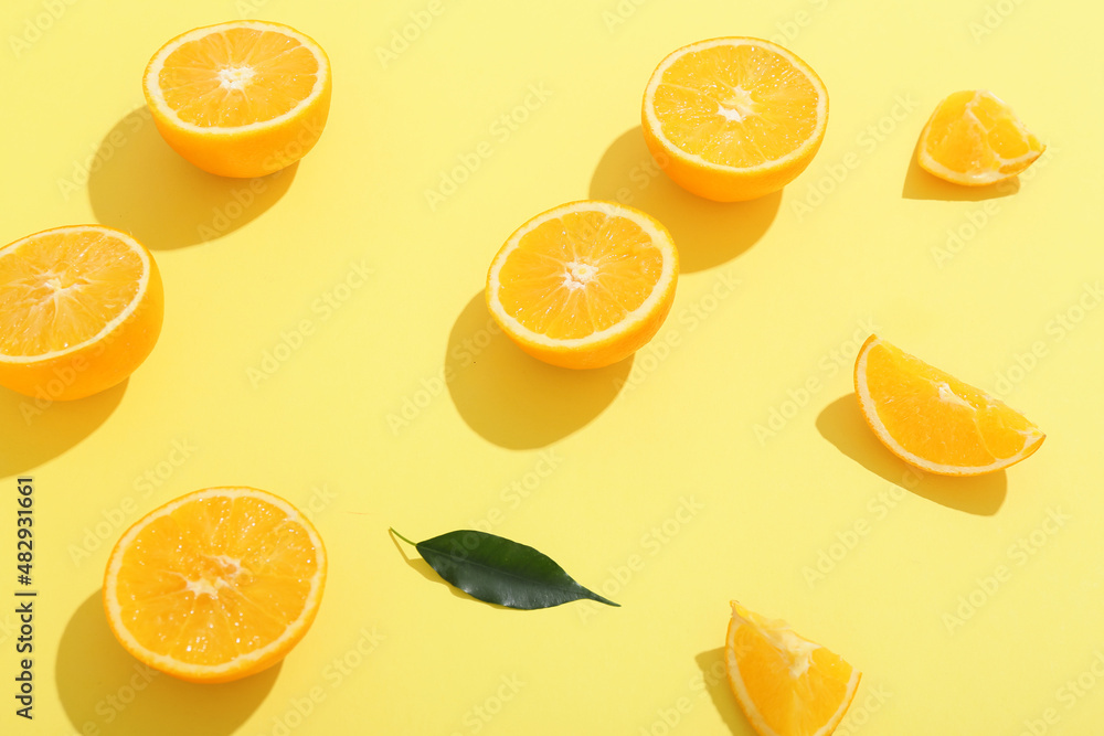 Fresh cut oranges on yellow background