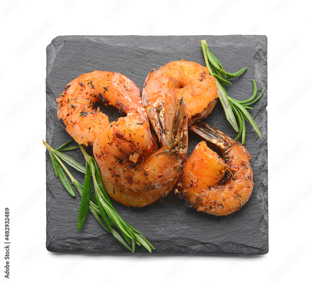 Board of tasty shrimp tails with spices on white background