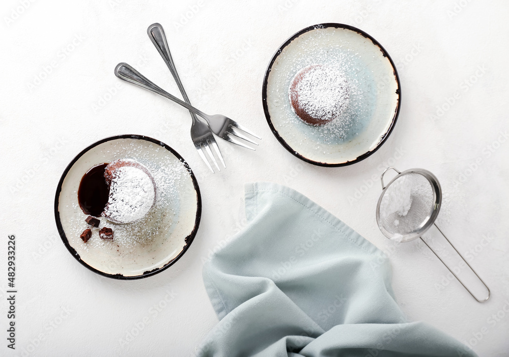 Plates with tasty lava cake fondant on white background