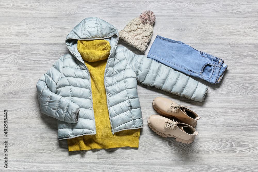 Female winter clothes and shoes on grey wooden background