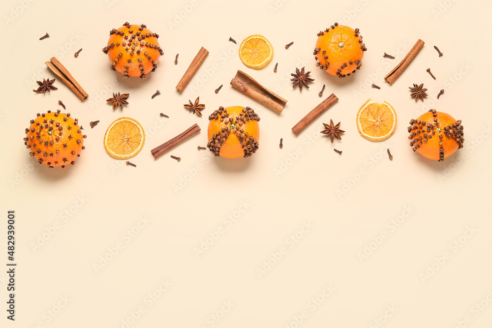 Handmade Christmas decoration made of tangerines with cloves on beige background