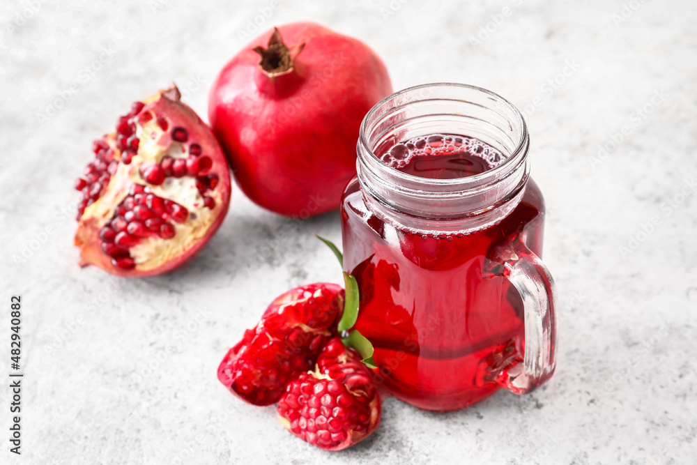 Mason jar of delicious pomegranate juice on white background