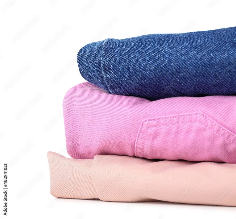 Stack of stylish female pants on white background, closeup