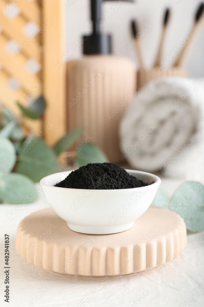 Bowl with activated charcoal tooth powder on table