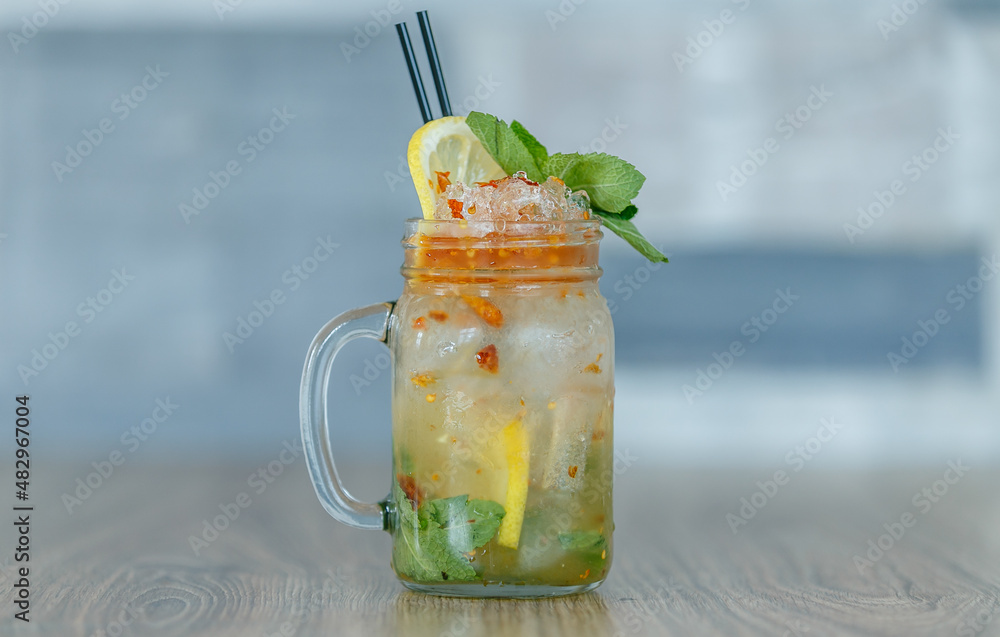 Fresh passion fruit with crushed ice and lemon and straw on table with blueish background