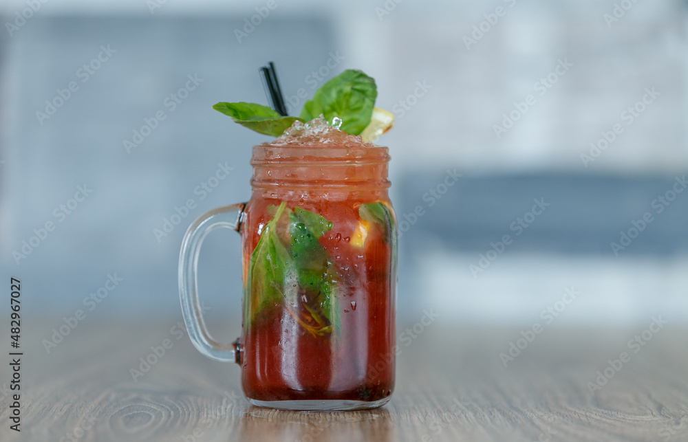 Fresh pomegranate lemonade with crushed ice and mint and straw on table with wood background