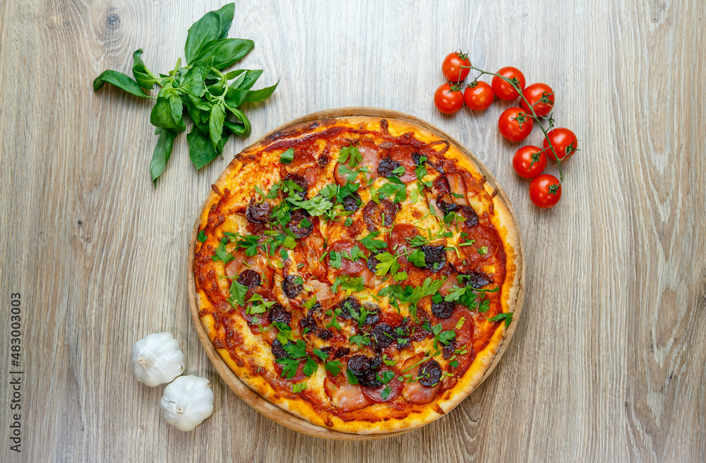 pizza with sausage, ham, salami and parsley