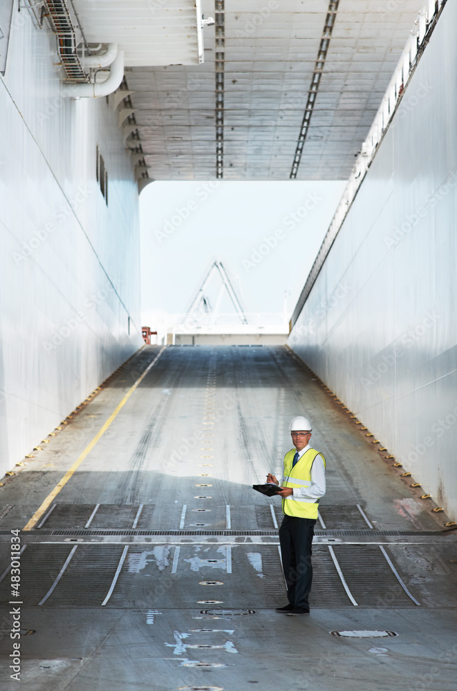 Any companys copyspace dream. A smiling foreman taking notes while standing on a ramp.