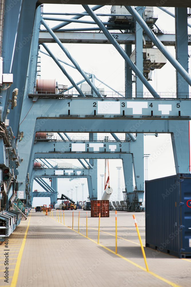 The evolution of engineering. Cranes shipping supplies at the harbor.