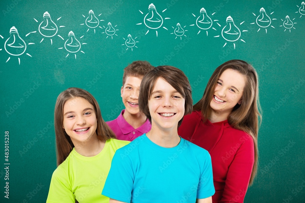 group portrait of happy smiling primary school students on blackboard background