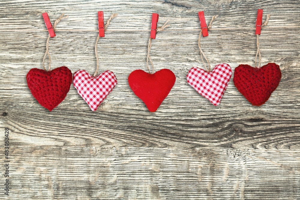 Hand made colored hearts over a wooden background