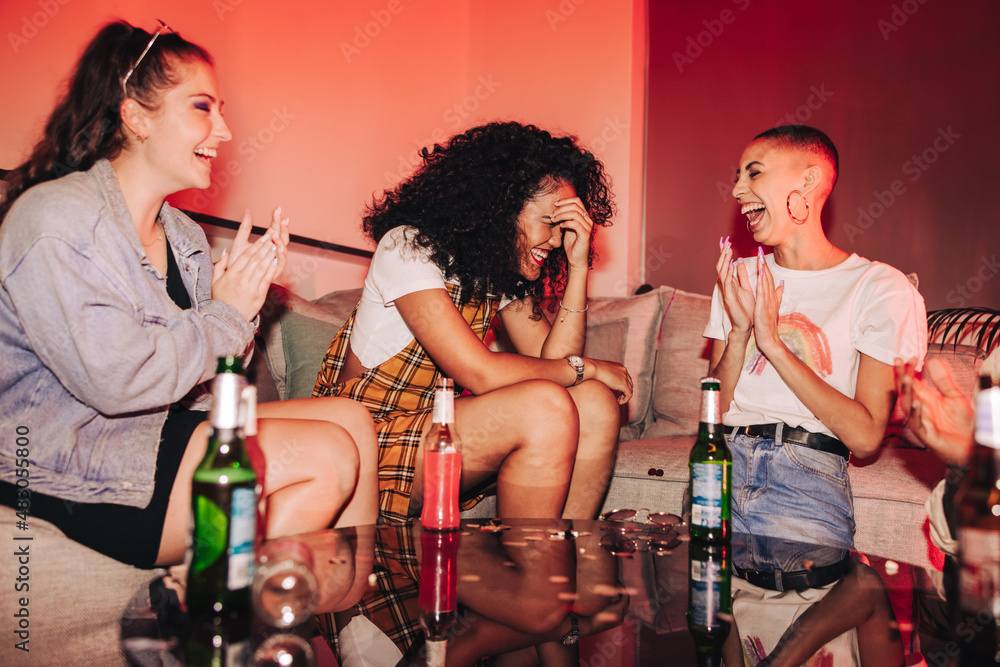 Friends cheering their shy friend on at a house party