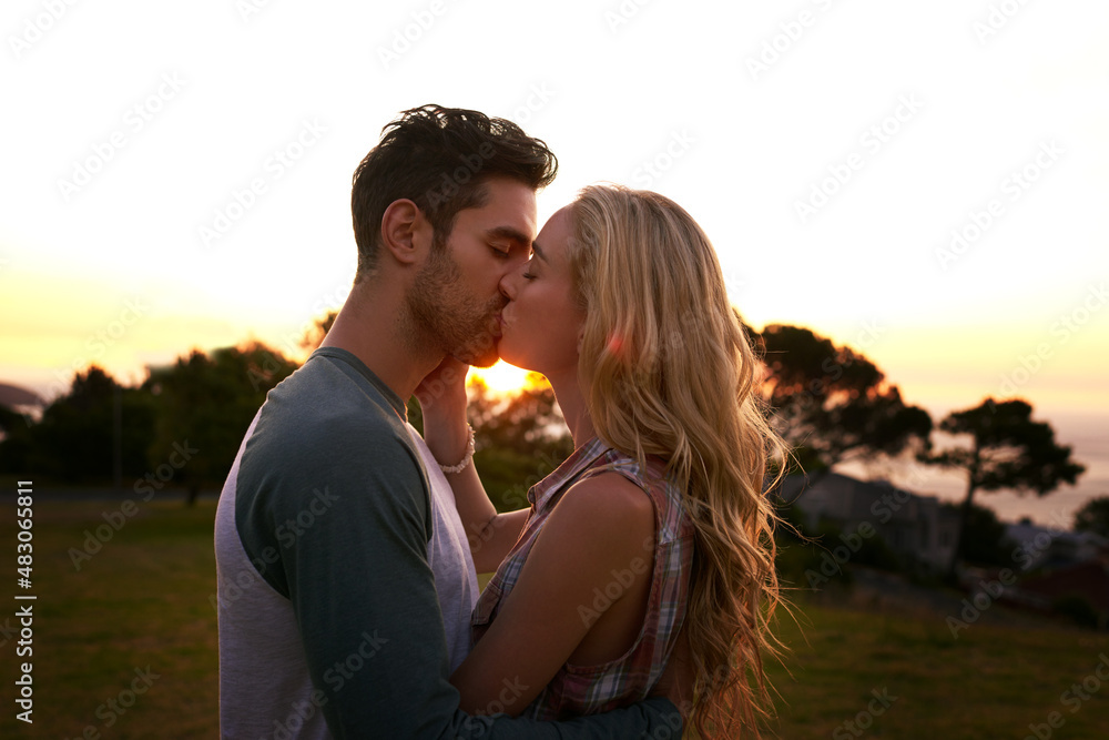 Smooches at sunset. Cropped shot of an affectionate young couple outdoors.