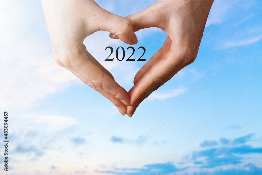 New year inspirational motivational, person holding a heart shaped hands with 2022 number inside.