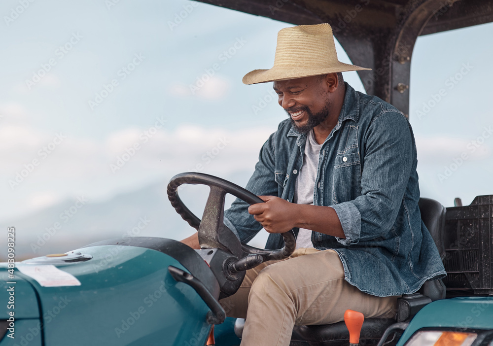 Whats a farmer without his tractor. Shot of a mature man driving a tractor on a farm.