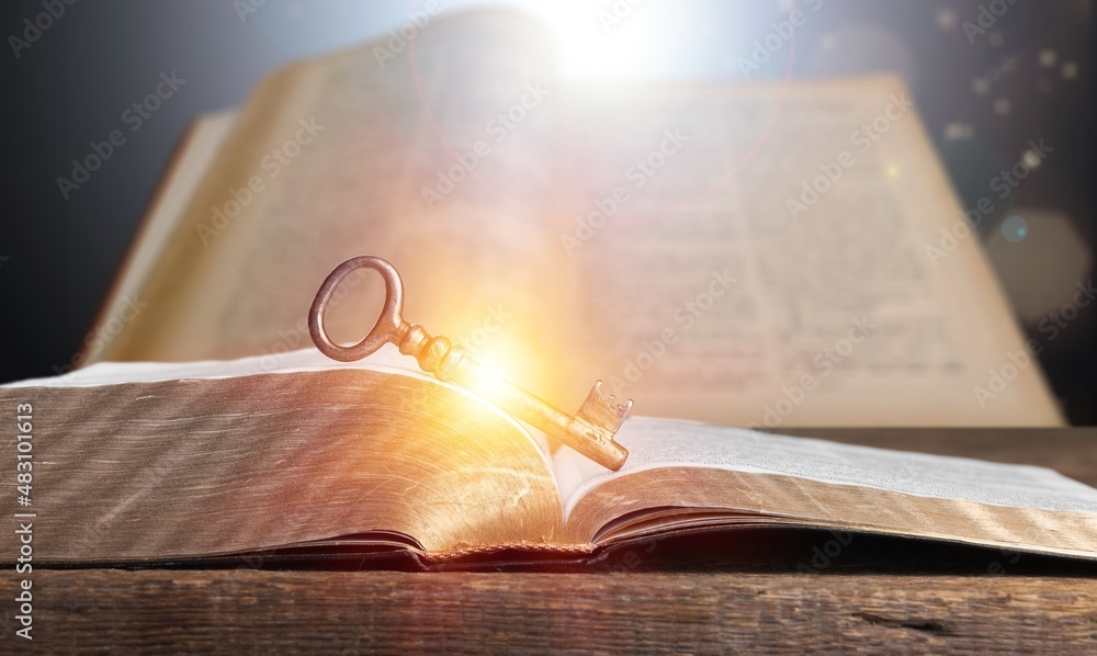 Old open antique book on table with vintage key