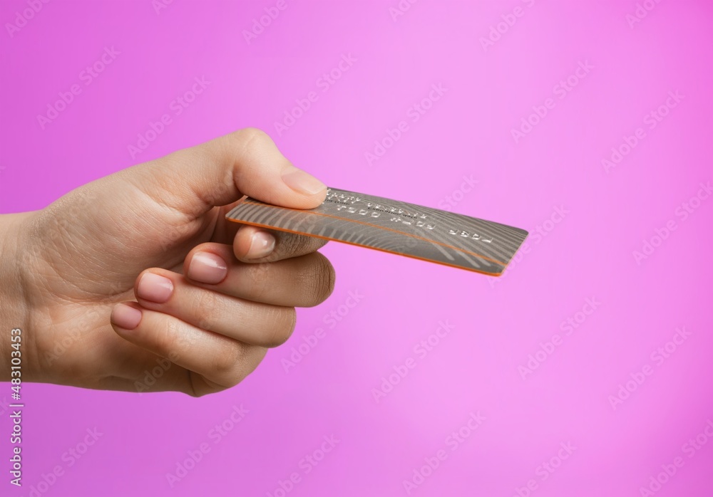 Young female hand and template Bank credit card with online service on background