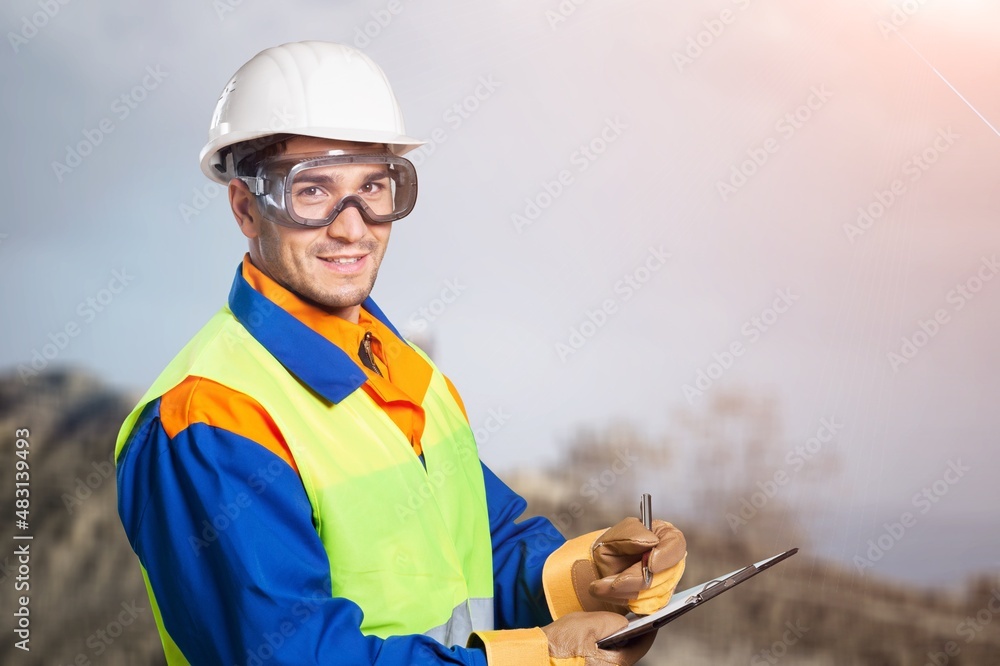 A young coal mine foreman wearing a hard hat work on site