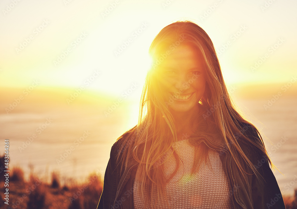 Wherever you are, be all there. Portrait of a woman standing on a hill top at sunset.