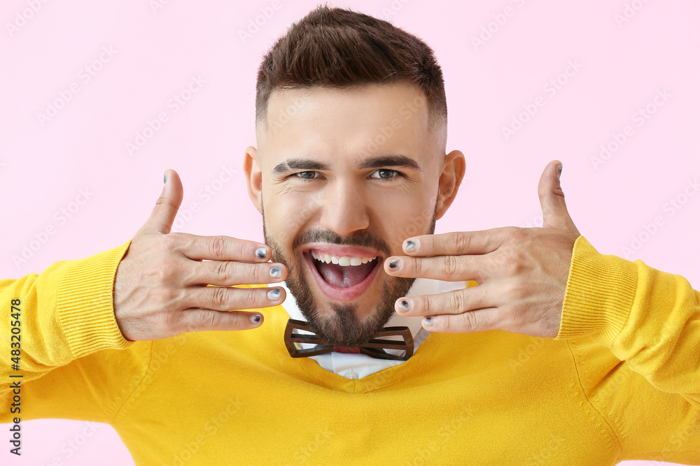 Portrait of happy man with trendy manicure on color background